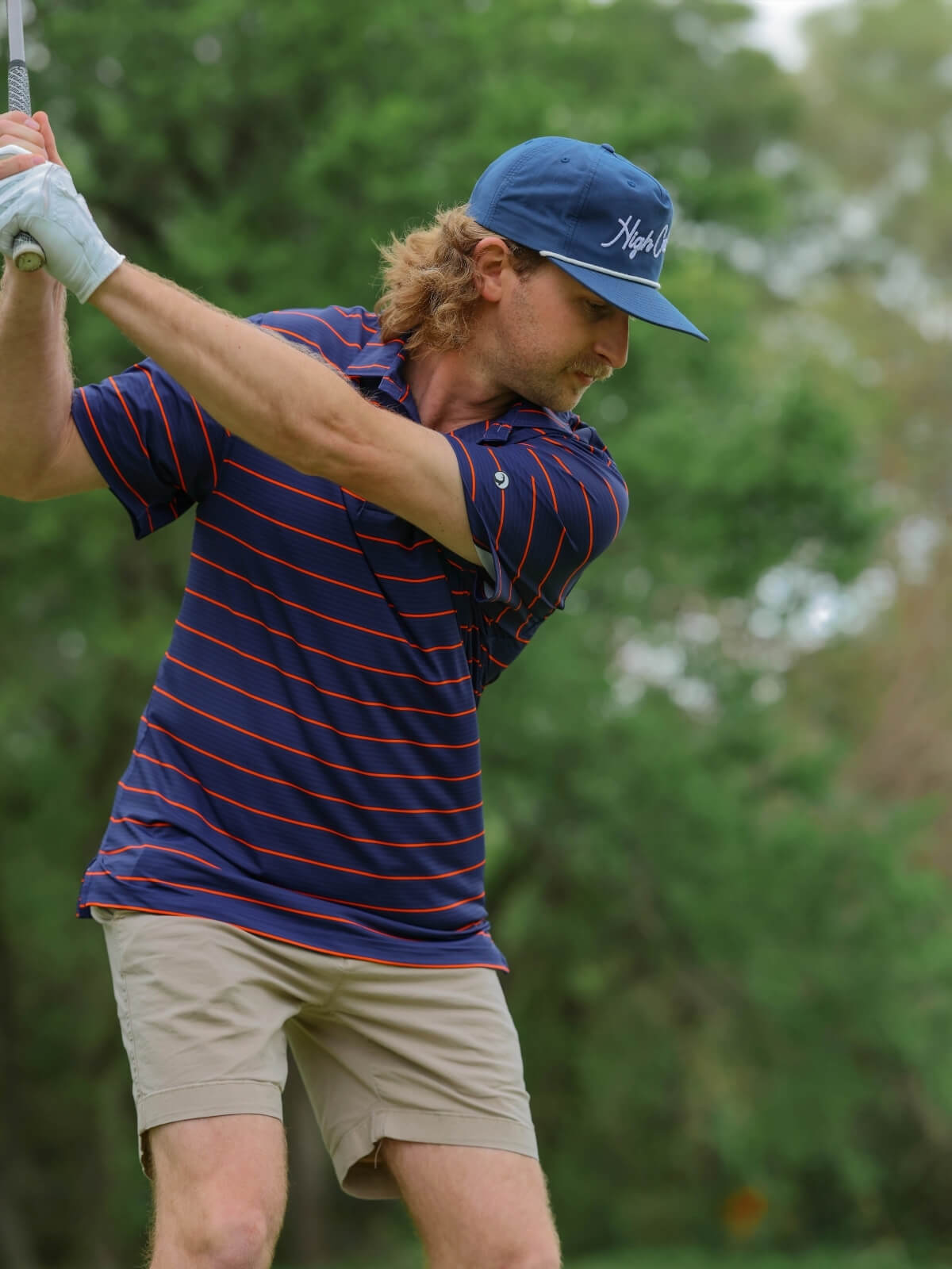Man playing golf wearing High Creek polos